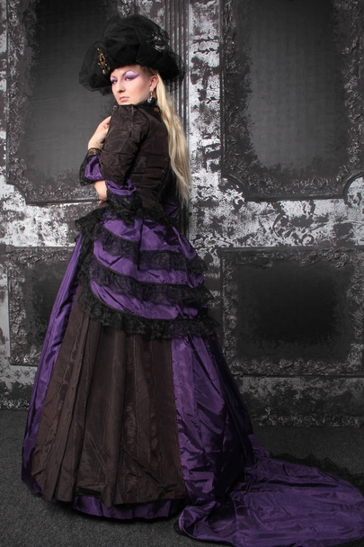 blonde žena nosí historické fialové černé dlouhé šaty - Fotografie, Obrázek