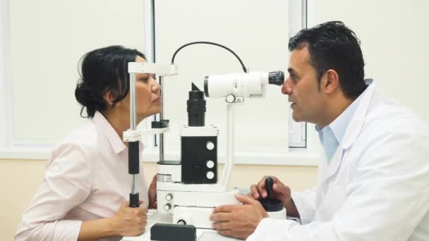 Un médico experto examina los ojos de los pacientes con un dispositivo
 - Imágenes, Vídeo