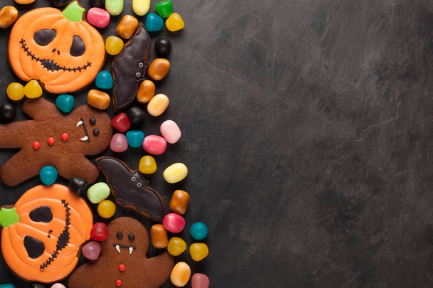 Halloween pumpkin, bat and gingerbread man-vampire cookies and colorful candy overhead shot with copy space - Photo, Image