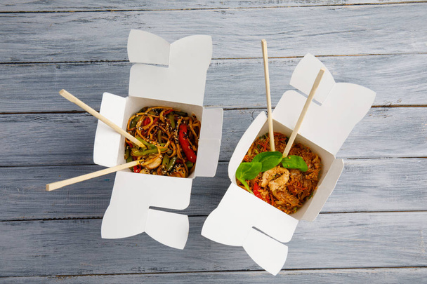 Noodles with vegetables in a box for export on a wooden table - Foto, Imagem