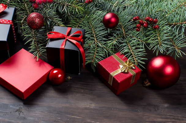 Black and red  christmas  gift  box with red ribbon and fir bran - Φωτογραφία, εικόνα