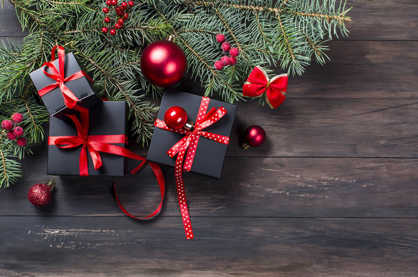 Caixa de presente de Natal preto com fita vermelha e ramos de abeto
 - Foto, Imagem