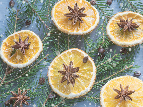 Christmas background with citrus fruit of orange slices and star anise on the spruce branches. - Zdjęcie, obraz