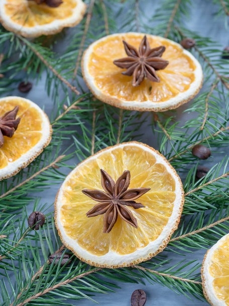 Christmas background with citrus fruit of orange slices and star anise on the spruce branches. - Фото, зображення