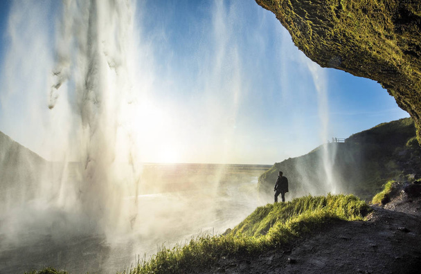 Touristen stehen vor dem Seljalandsfoss, einem der bekanntesten Wasserfälle in Südisland, Seljalandsfoss, Island - Foto, Bild