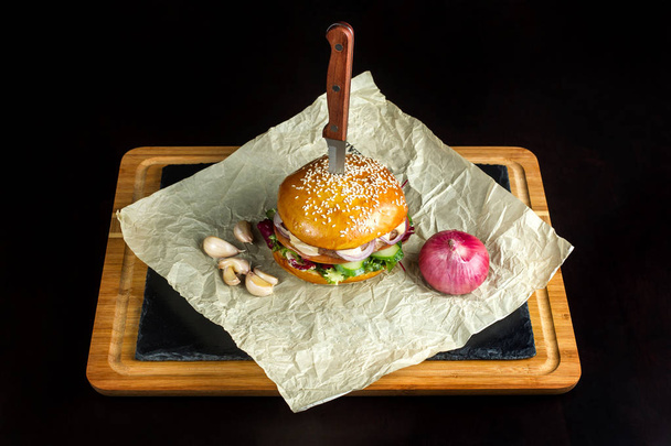 Hamburger with garlic is on kraft paper. - Фото, зображення