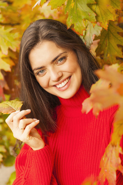 Bruntte sonriente en el bosque durante un otoño
. - Foto, imagen