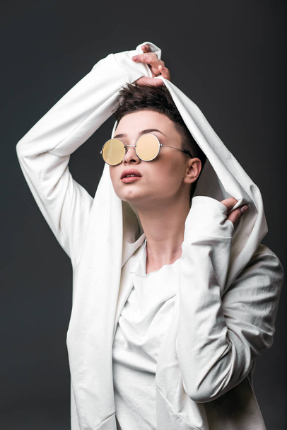 Ritratto di una bella ragazza che indossa un cappotto bianco e occhiali da sole
 - Foto, immagini