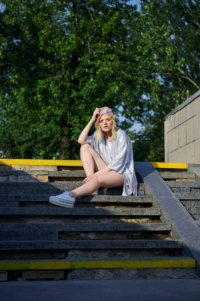 Jeune fille blonde en chapeau mousseux assis sur les escaliers
 - Photo, image