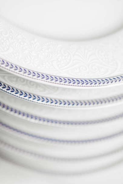 Набір чистих білих тарілок, розташованих у шафі
 - Фото, зображення