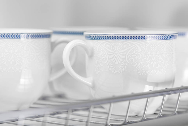 Set of clean white cups located on the shelf - Photo, Image