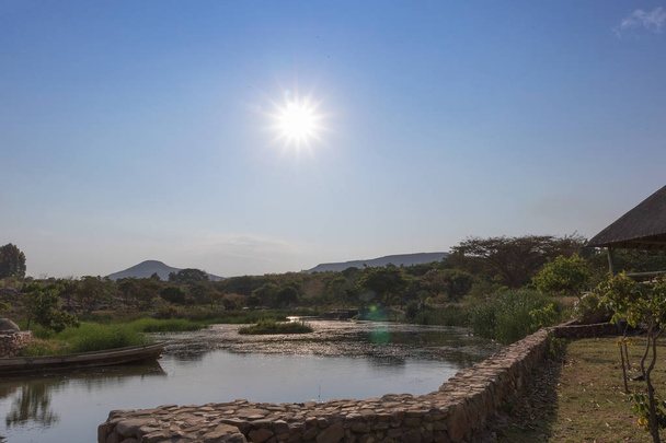 Вид на африканское озеро с лодкой и горами. Лубанго. Ангола
. - Фото, изображение