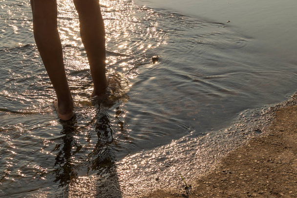 Afrikai fiatal lány lába felett a víz naplemente lig járni - Fotó, kép