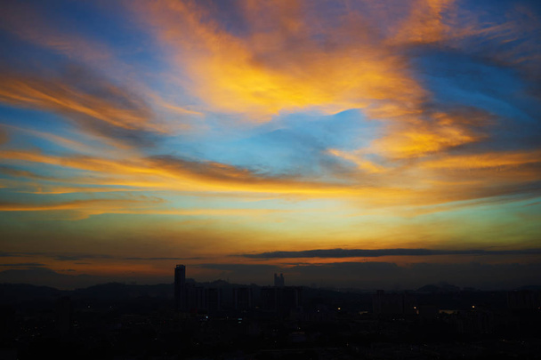 Όμορφη φυσική ηλιοβασίλεμα Ανατολή στον ορίζοντα της πόλης σιλουέτες και καταπληκτικό πορτοκαλί σύννεφο μπλε ουρανό πάνω από το . - Φωτογραφία, εικόνα