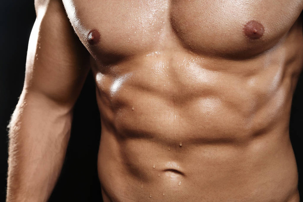 Muscular man on dark background, closeup - Foto, immagini