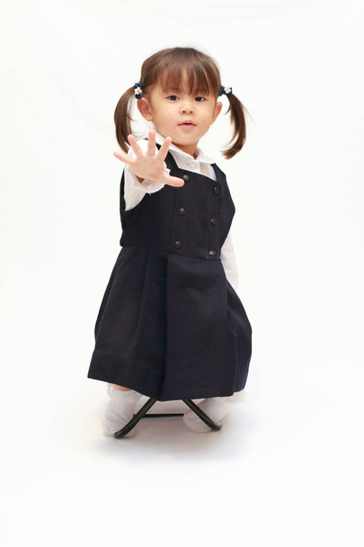 Японская девушка на стуле играет в камень-ножницы-бумага в формальной одежде (2 года) (бумага
) - Фото, изображение