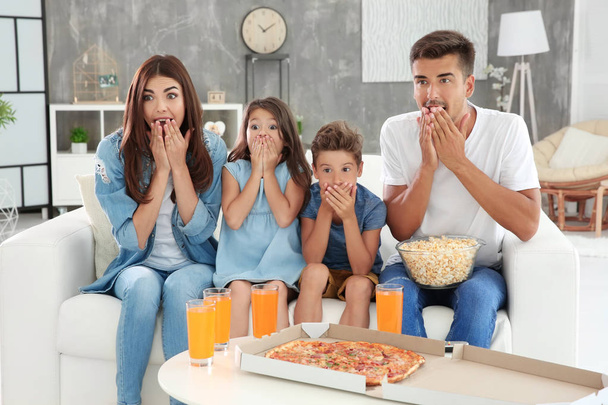 Happy family watching TV on sofa at home - Foto, Imagem