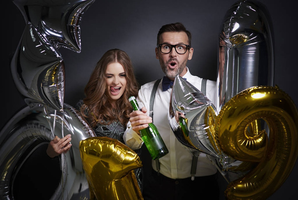 Χαρούμενο ζευγάρι με σαμπάνια και μπαλόνια γιορτάζει - Φωτογραφία, εικόνα