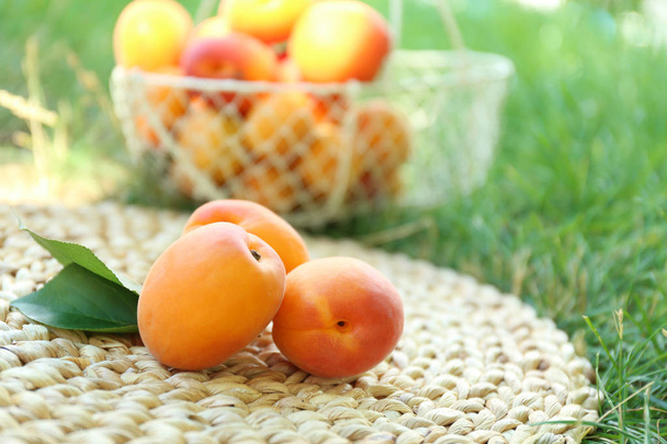 Fresh apricots on wicker mat - Foto, Imagen