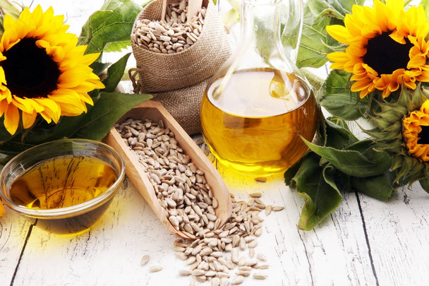 Sunflower oil, sunflower and seeds on white background - Photo, Image