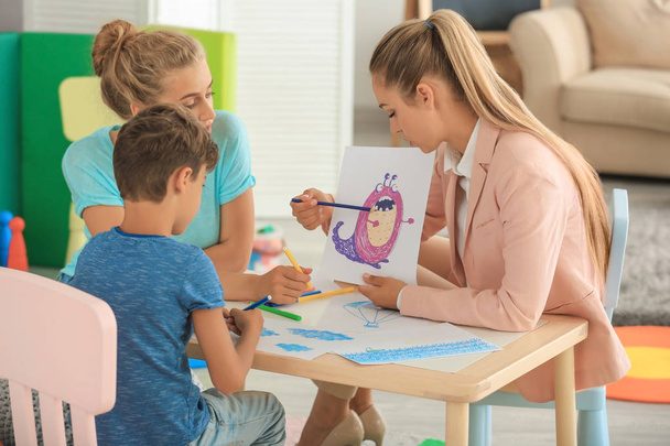 Young child psychologist working with family in office - Photo, image