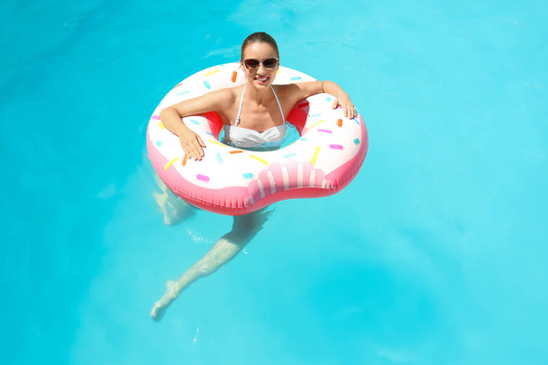 Young woman with inflatable donut - Foto, afbeelding