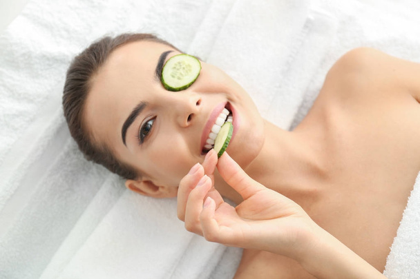 Young woman with cucumber slices  - 写真・画像