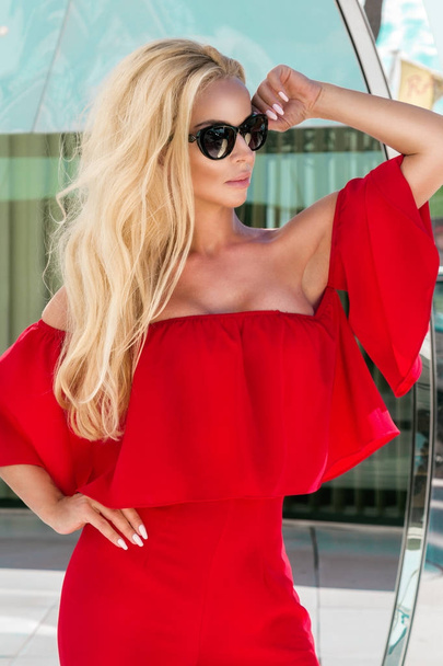 Krásné elegantní Dámské modelevé model v červených šatech stojící před luxusních hotelů a butiky v Cannes, Francie - Fotografie, Obrázek