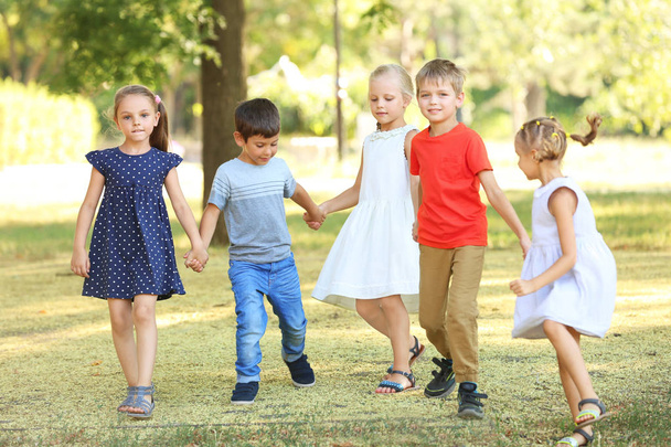 Ryhmä lapsia puistossa aurinkoisena päivänä
 - Valokuva, kuva