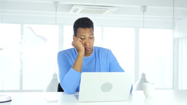 Сплячий молодий афроамериканський чоловік сидить на роботі
 - Кадри, відео