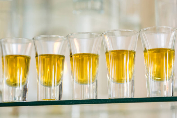 Услуги общественного питания. Празднование. стаканы с алкоголем, помещенными на стекло. Пять стаканов алкоголя
. - Фото, изображение