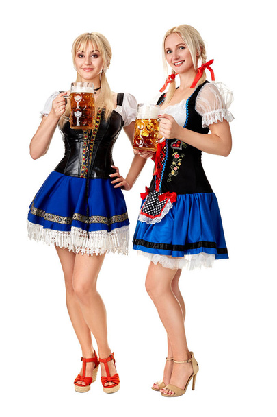 Täyspitkä muotokuva kahdesta vaaleasta naisesta, joilla on perinteinen puku ja joilla on valkoisella pohjalla eristetyt olutlasit
. - Valokuva, kuva