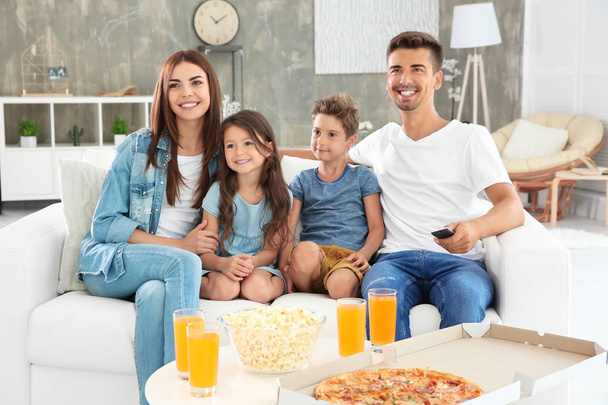 Happy family watching TV on sofa at home - Foto, Imagen