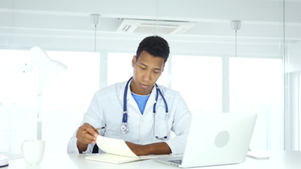 Médico afroamericano escribiendo informes médicos de pacientes, medicina
 - Imágenes, Vídeo
