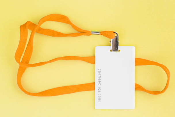 Κενή κάρτα Id / εικονίδιο με ένα πορτοκαλί ζώνη σε κίτρινο φόντο. - Φωτογραφία, εικόνα