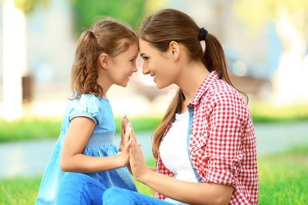 Cute little girl with mother in park on sunny day - Photo, Image