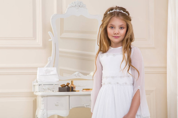 Impresionante belleza joven modelo en el vestido de comunión blanca se encuentra en un elegante palacio
 - Foto, Imagen