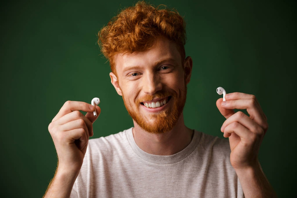 Close-up of young smiling curly redhead bearded young man in whi - Fotó, kép