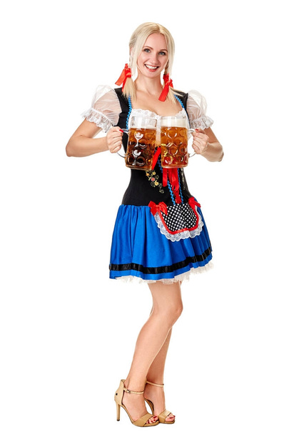 Full length portrait of a blond woman with traditional costume holding beer glasses isolated on white background. - Photo, image