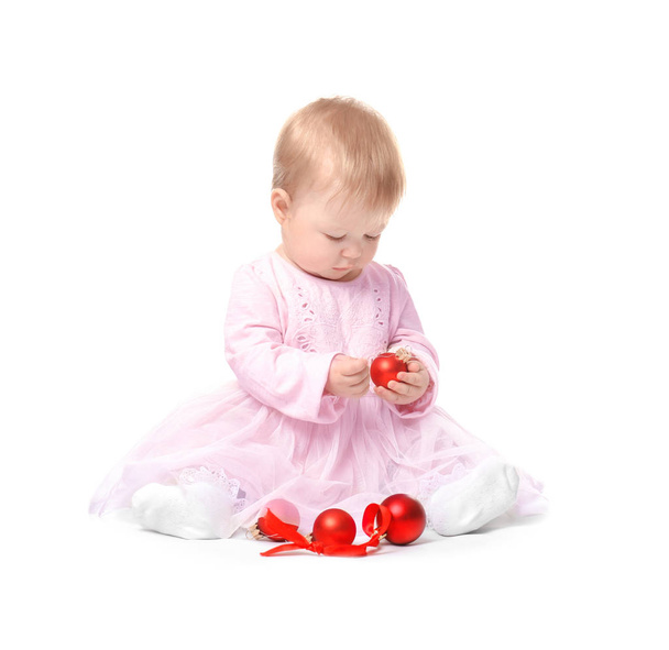 Adorable baby playing with Christmas baubles on white background - Foto, afbeelding