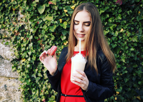 woman with milk cocktail and macaroon in hands - Photo, Image