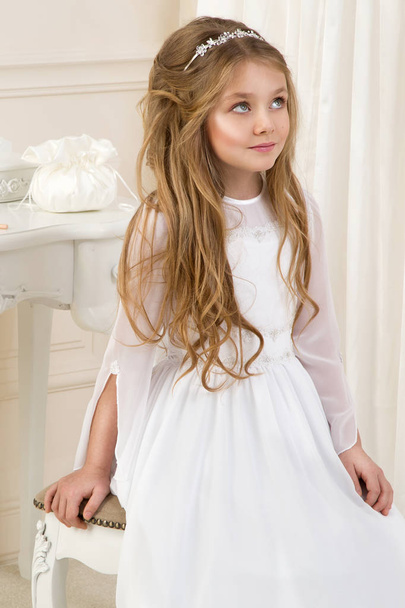 Stunning beauty young girl model in the white communion dress stands in an elegant palace - Photo, image