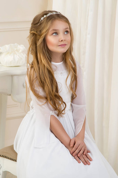 Impresionante belleza joven modelo en el vestido de comunión blanca se encuentra en un elegante palacio
 - Foto, imagen
