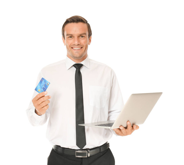 Young businessman holding credit card while using laptop on white background - Fotografie, Obrázek