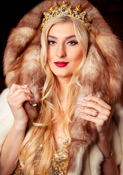 glamorous blonde in golden dress, crown, beautiful accessories and fur coat - Photo, image