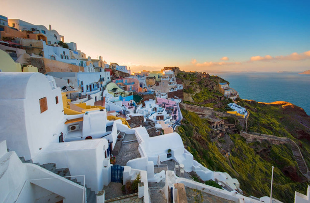 Miasto Oia na wyspie Santorini, Grecja. Tradycyjne i słynne domy i kościoły z niebieskimi kopułami nad Kalderą, Morze Egejskie - Zdjęcie, obraz