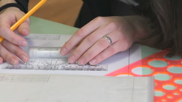 Schoolgirl draw geometric figures in notebook - Footage, Video
