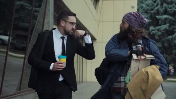 Geschäftsmann läuft mit Bettler auf der Straße - Filmmaterial, Video