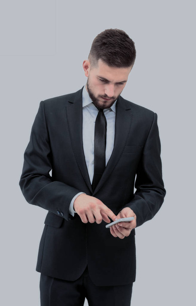Handsome businessman in suit using the phone in office - Fotó, kép