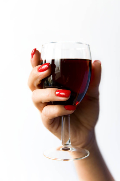A glass of red wine in a beautiful woman's hand. - Foto, imagen